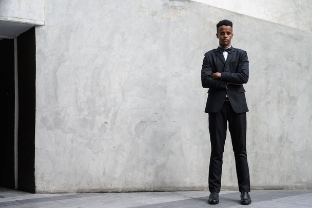 Young handsome African businessman wearing suit against concrete - Fotoğraf, Görsel