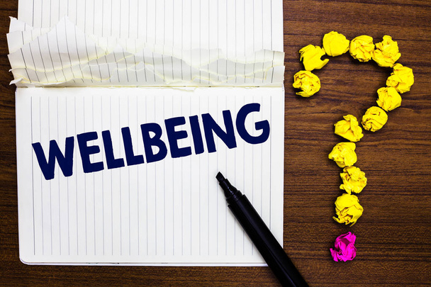 Writing note showing Wellbeing. Business photo showcasing A good or satisfactory condition of existence including health Notebook marker crumpled paper forming question mark wooden background - Photo, Image