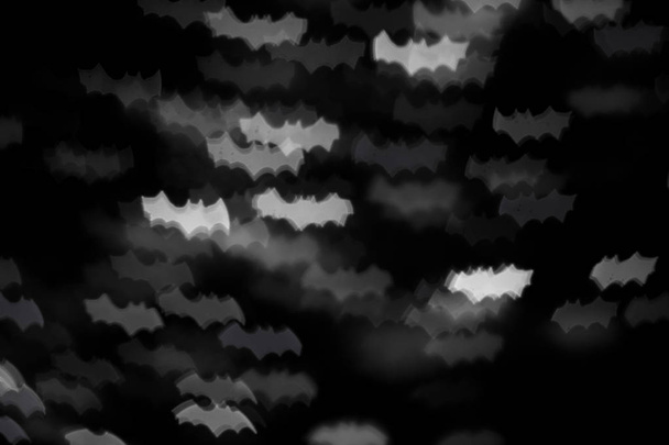 defocused white bats silhouette ghosts on black for halloween background - holidays, decoration and party concept - Photo, image
