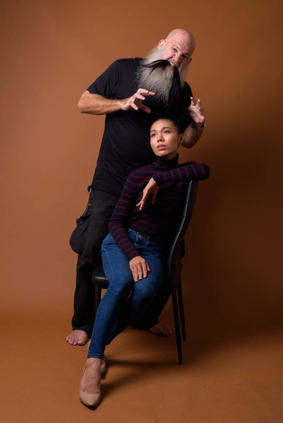 Mature bearded bald man with young Asian transgender woman - Photo, Image