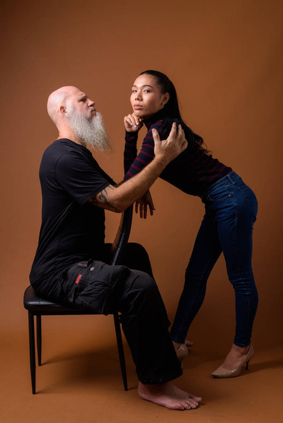Olgun sakallı kel adam genç Asya travesti kadın ile - Fotoğraf, Görsel
