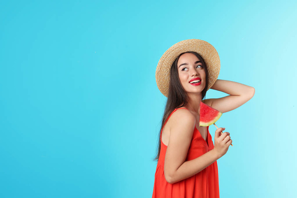 Beautiful young woman posing with watermelon on color background - Foto, Imagen