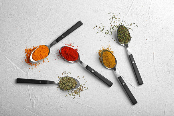 Flat lay composition with different aromatic spices on light background - 写真・画像