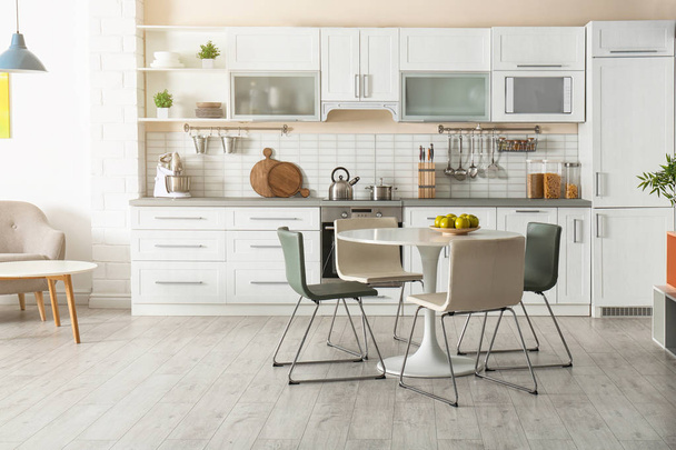 Stylish kitchen interior with dining table and chairs - Fotó, kép