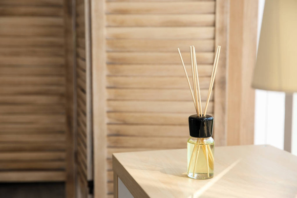 Aromatic reed air freshener on table indoors - Foto, imagen
