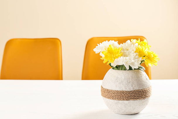 Vase with blooming flowers on table indoors - Foto, afbeelding