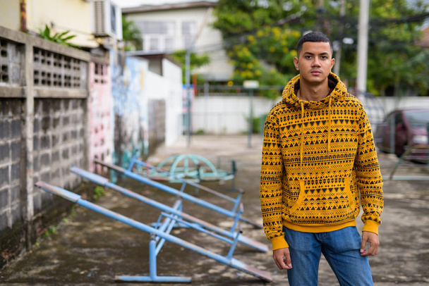 Young multi-ethnic Asian man in the streets outdoors - 写真・画像
