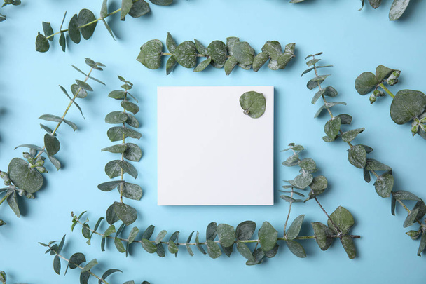 Fresh eucalyptus leaves and blank card with space for design on color background, top view - Fotoğraf, Görsel