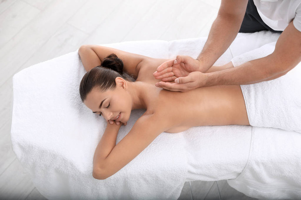 Relaxed woman receiving back massage in wellness center - Photo, Image