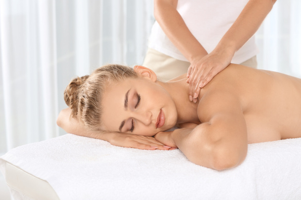 Relaxed woman receiving neck massage in wellness center - Фото, зображення