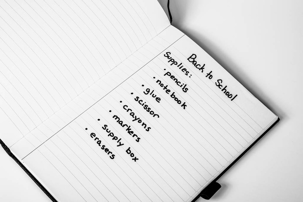  Handwritten shopping list of back to school supplies written on page of a notebook - Foto, imagen