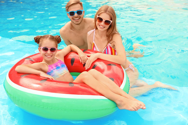 Happy family in pool on sunny day - Фото, изображение