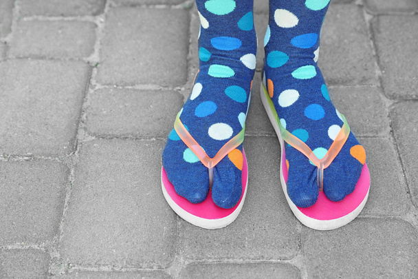 Woman wearing bright socks with flip-flops standing outdoors - Photo, Image
