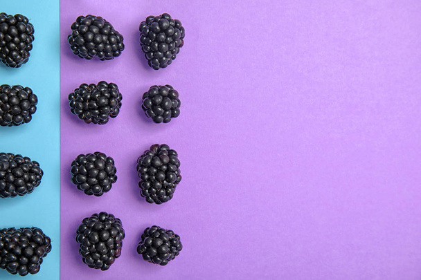 Flat lay composition with ripe blackberries on color background - Photo, image