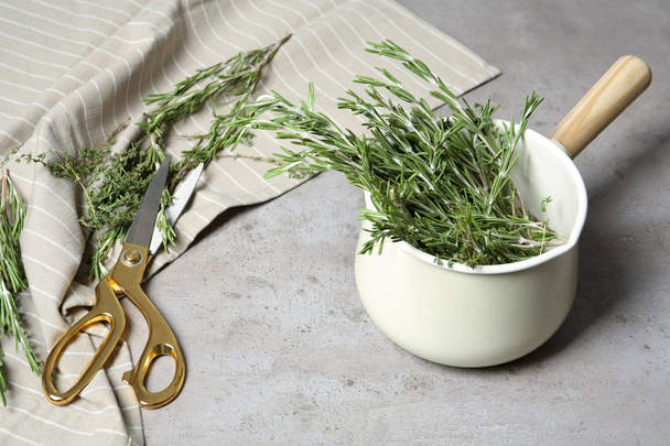 Fresh green rosemary in cookware and scissors on table. Aromatic herbs - Foto, Imagem