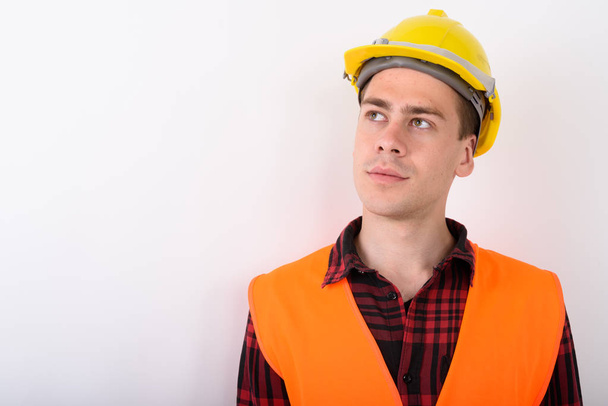 Fiatal jóképű férfi építőmunkás fehér háttér - Fotó, kép