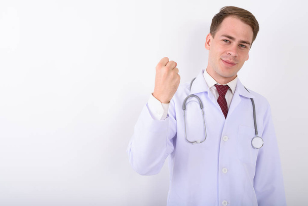 Young handsome man doctor against white background - Photo, Image