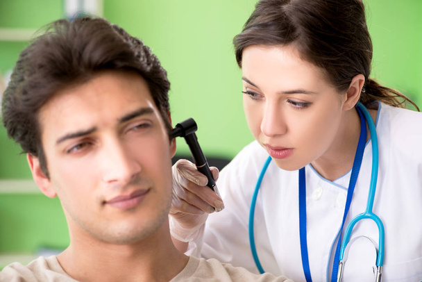 Жінка-лікар перевіряє вухо пацієнтів під час медичного огляду
  - Фото, зображення