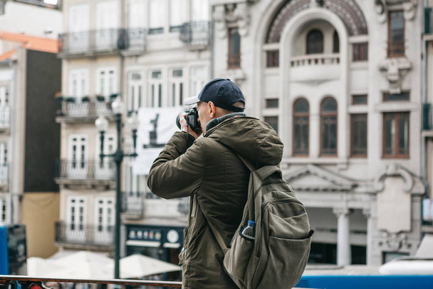 A professional travel photographer or tourist photographs a beautiful urban landscape in Porto in Portugal. Professional occupation or hobby - Photo, Image
