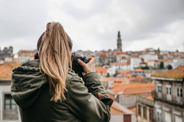 A professional travel photographer or tourist photographs a beautiful cityscape in Porto in Portugal. Professional photography or interesting hobby. - Photo, Image