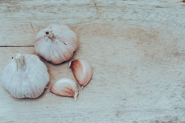 White garlic and garlic cloves on wooden floor - Foto, Bild