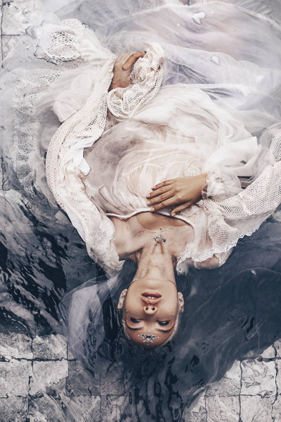 close up portrait of beautiful woman lying in water with fabric. Fashion concept - Foto, imagen