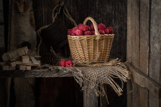 Rural still life with raspberries on rustic  table. fresh juicy berries over old wooden background - Fotó, kép