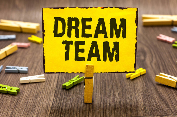 Text sign showing Dream Team. Conceptual photo Prefered unit or group that make the best out of a person Clothespin holding yellow paper note several clothespins wooden floor - Photo, Image