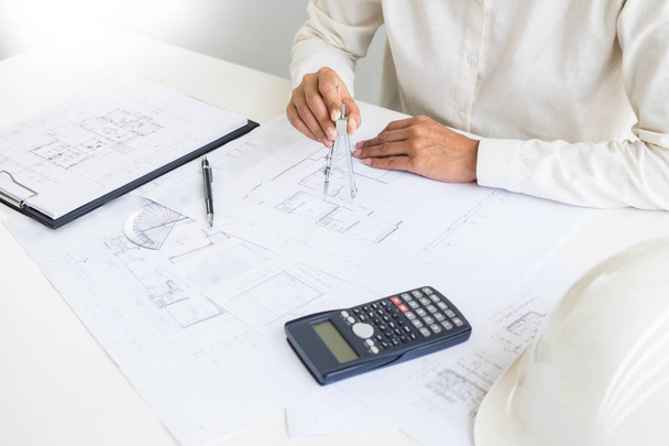 Close-up Of Person's engineer Hand Drawing Plan On Blue Print with architect equipment, Architects discussing at the table, team work and work flow construction concept. - Photo, Image