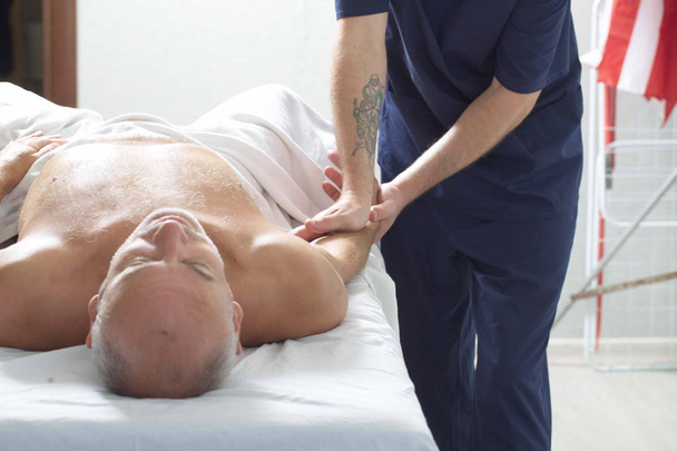 masážní terapeut dělá z muže maséra - Fotografie, Obrázek