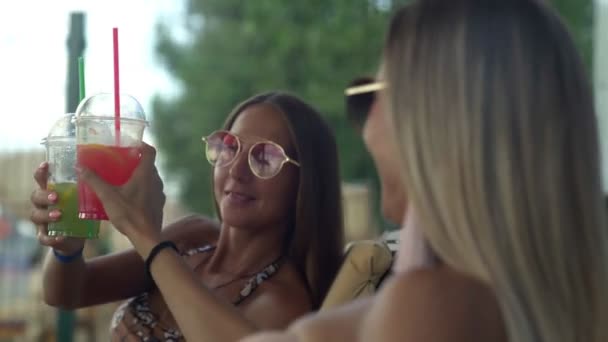 Šťastné ženy ve slunečních brýlích se těší na drink na krásné pláži - Záběry, video