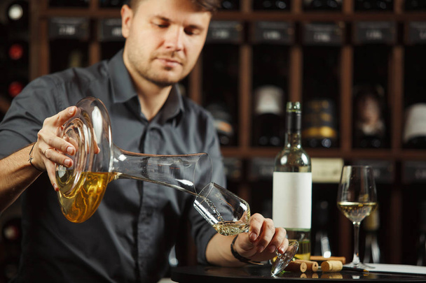Sommelier pours white wine from decanter to the glass - Foto, Imagen