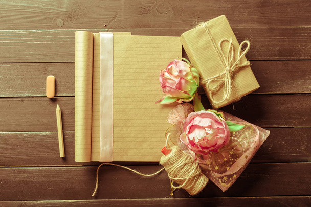 flowers and a notebook on wooden background - Фото, зображення