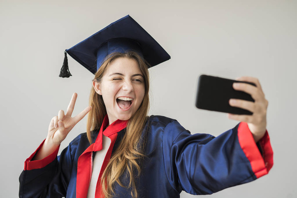 Young female student graduating from university - Фото, изображение