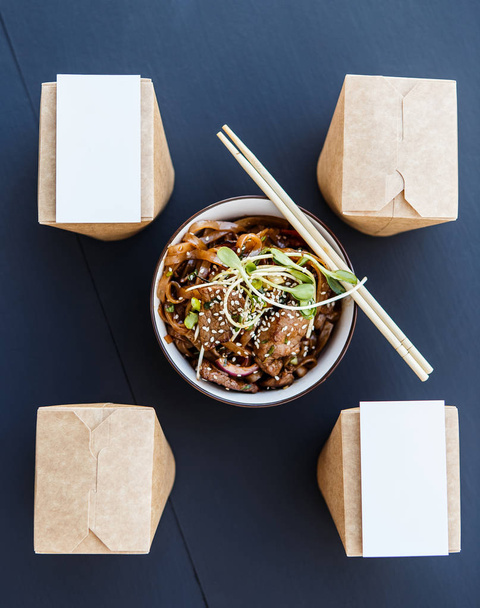Wok noodles βοείου κρέατος με παράδοση κουτιά και επαγγελματική κάρτα - Φωτογραφία, εικόνα
