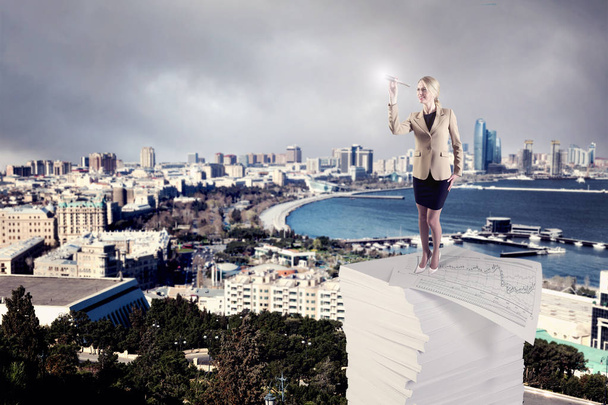 Uma mulher de negócios em pé sobre uma pilha de papéis de negócios
 - Foto, Imagem