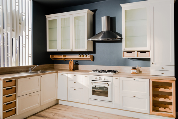 intérieur de cuisine moderne avec comptoirs de cuisine en bois blanc, étagères et cuisinière
 - Photo, image