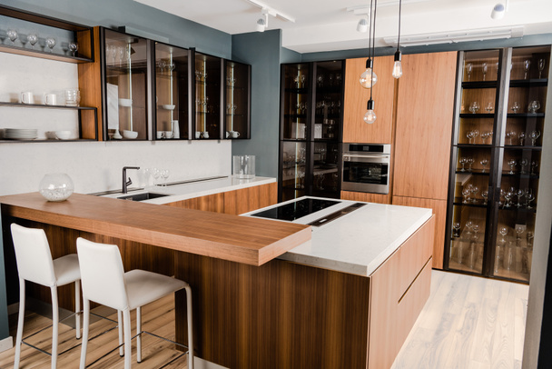 intérieur de la cuisine de luxe en bois avec des meubles confortables et de nombreuses étagères
 - Photo, image