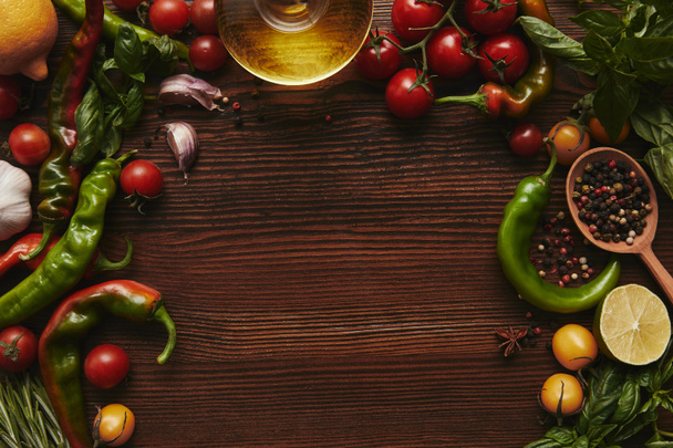 top view of oil, seasonings and vegetables on wooden background - Photo, image