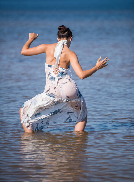 Jovem mulher elegante em vestido posando no fundo do mar. Morena nua Sexy desfrutando de verão na praia
 - Foto, Imagem