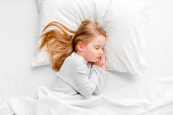 little girl sleeping in white bed - 写真・画像