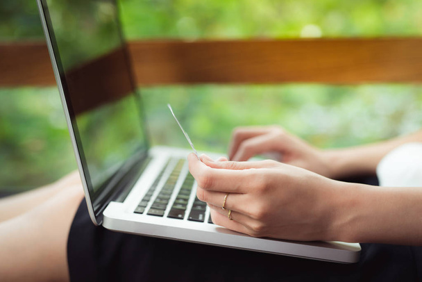 Asiatin kauft online ein, während sie am Fenster im kreativen Büro oder Café sitzt - Foto, Bild