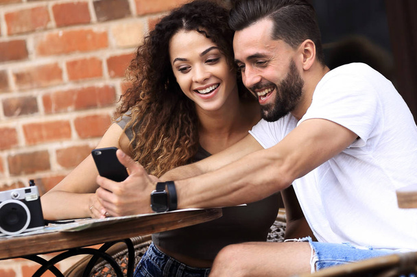 Lovely young couple looking at smart phone at cafe - Photo, image