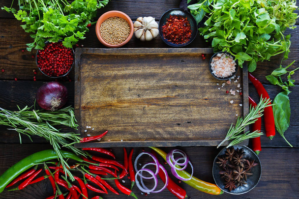 wooden board surrounded vegetables and greens  - Photo, image