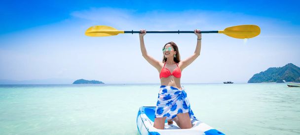 Branner van Aziatische vrouw op de boot van de kajak in Andaman blauwe zee en blauwe hemel achtergrond locatie in Phuket island, Thailand. - Foto, afbeelding
