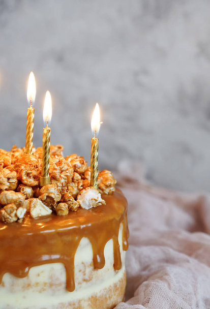 close up of homemade cake with caramel, sweet popcorn and sparklers - Foto, immagini