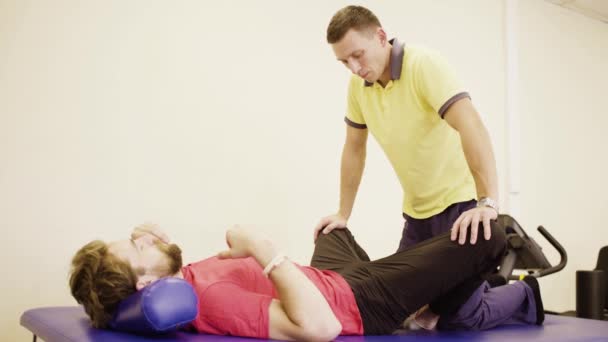 Arts doet stretching oefeningen voor gehandicapte man - Video