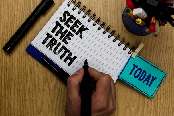Writing note showing Seek The Truth. Business photo showcasing Looking for the real facts Investigate study discover Man holding marker notebook clothespin reminder wooden table markers - Photo, Image
