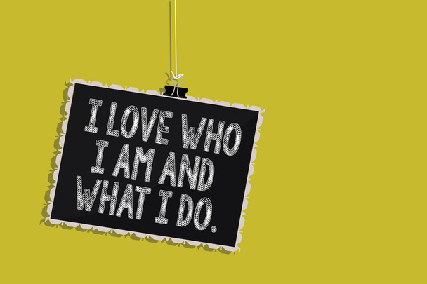 Текст почерка I Love Who I Am And What I Do.. Concept meaning High self-stem being comfortable with your job Hanging blackboard message information sign yellow background
 - Фото, изображение