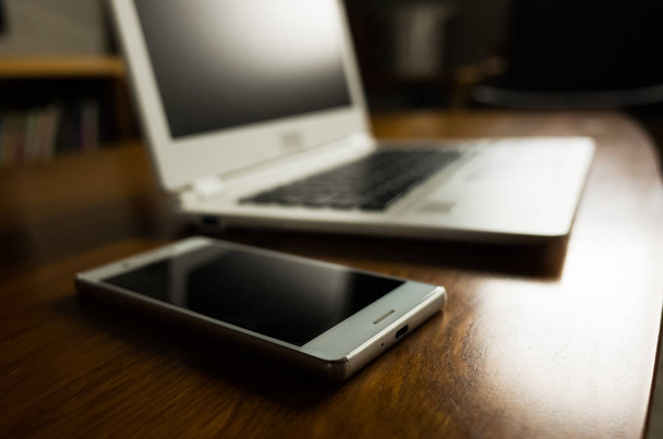 portátil y smartphone sobre la mesa sin nadie, concepto de trabajo en casa
 - Foto, Imagen